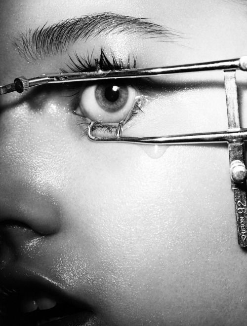 a woman with a pair of scissors on her eye