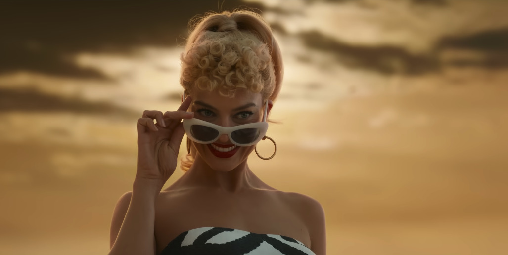 a woman wearing sunglasses and a bikini on the beach