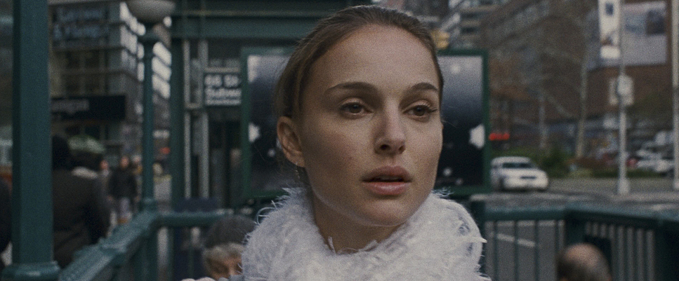 a woman in a white dress standing on a city street