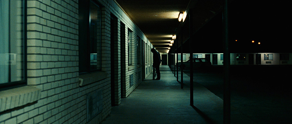 a dark hallway with a clock on the wall