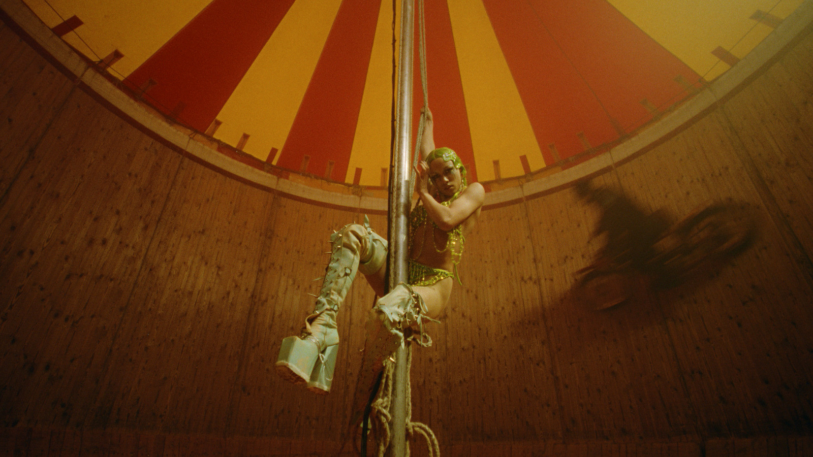 a man on a pole in front of a circus tent