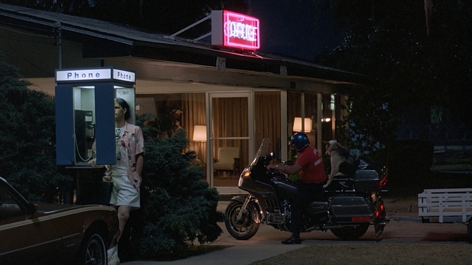 a man standing next to a motorcycle parked in front of a building