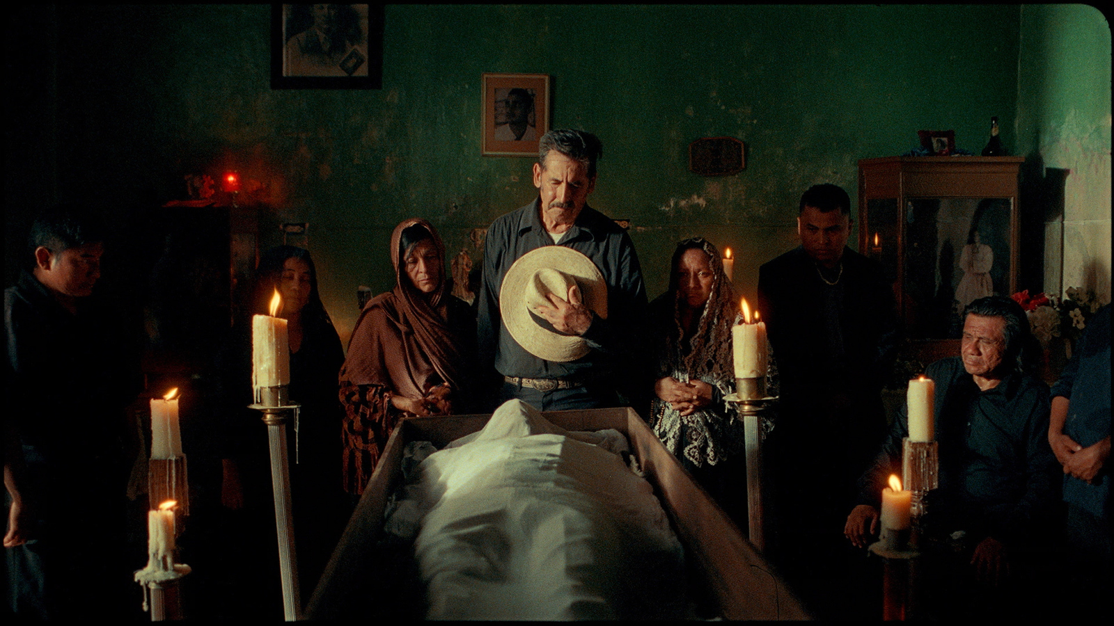 a group of people standing around a bed in a room