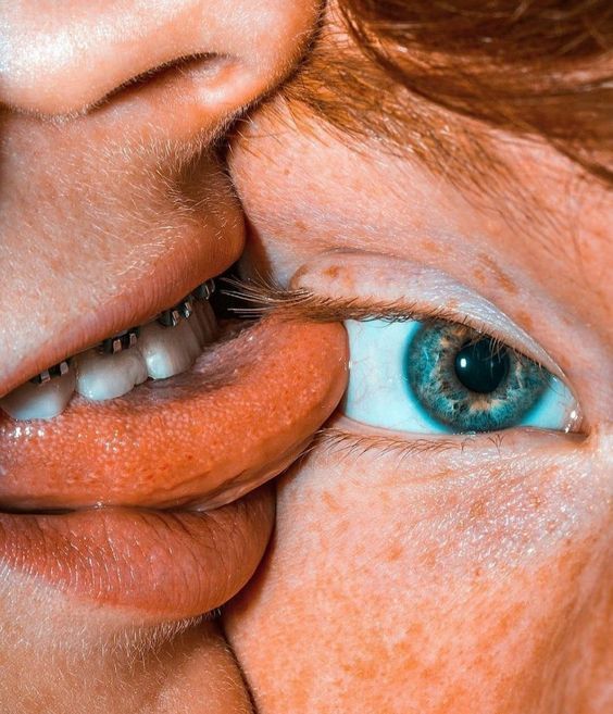 a close up of a woman's face with blue eyes