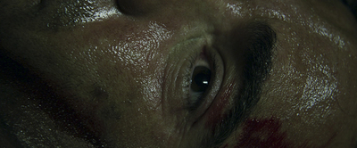 a close up of a man's face with a bleeding eye