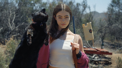 a woman holding a black cat in the desert