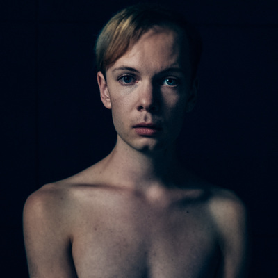 a shirtless man with no shirt standing in a dark room