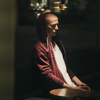 a man in a red hoodie sitting at a table