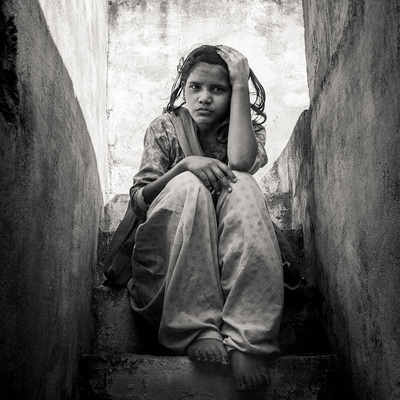 a girl sits on the steps of a building