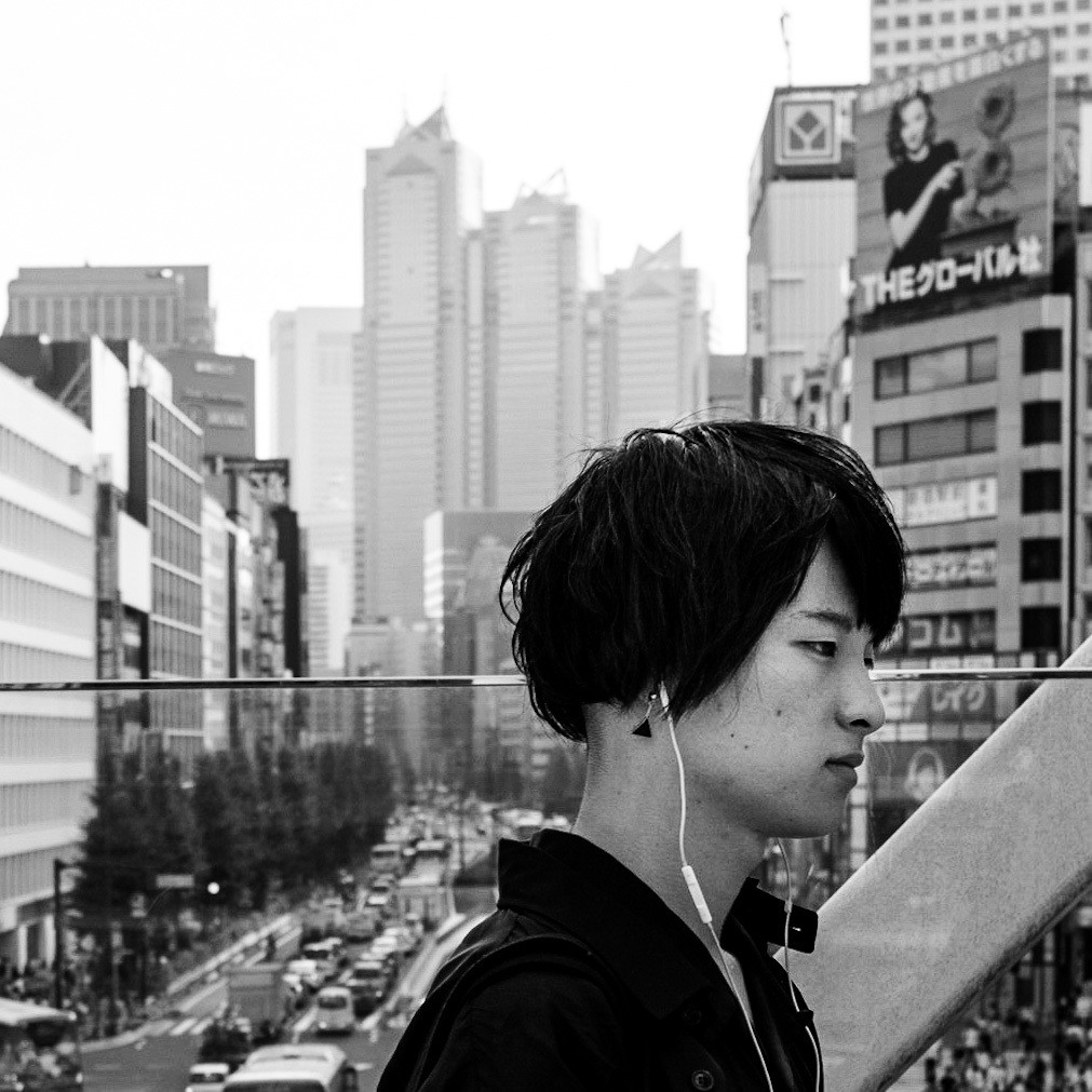 a man with earphones standing on a balcony