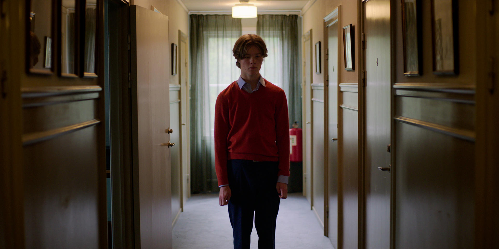 a man standing in a hallway between two doors