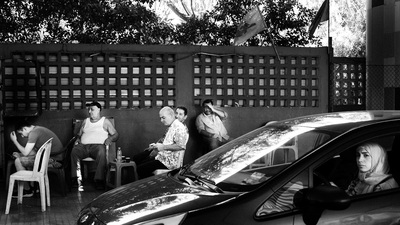 a group of people sitting at a table next to a car