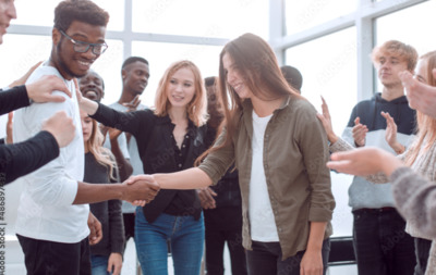 a group of people standing around each other shaking hands