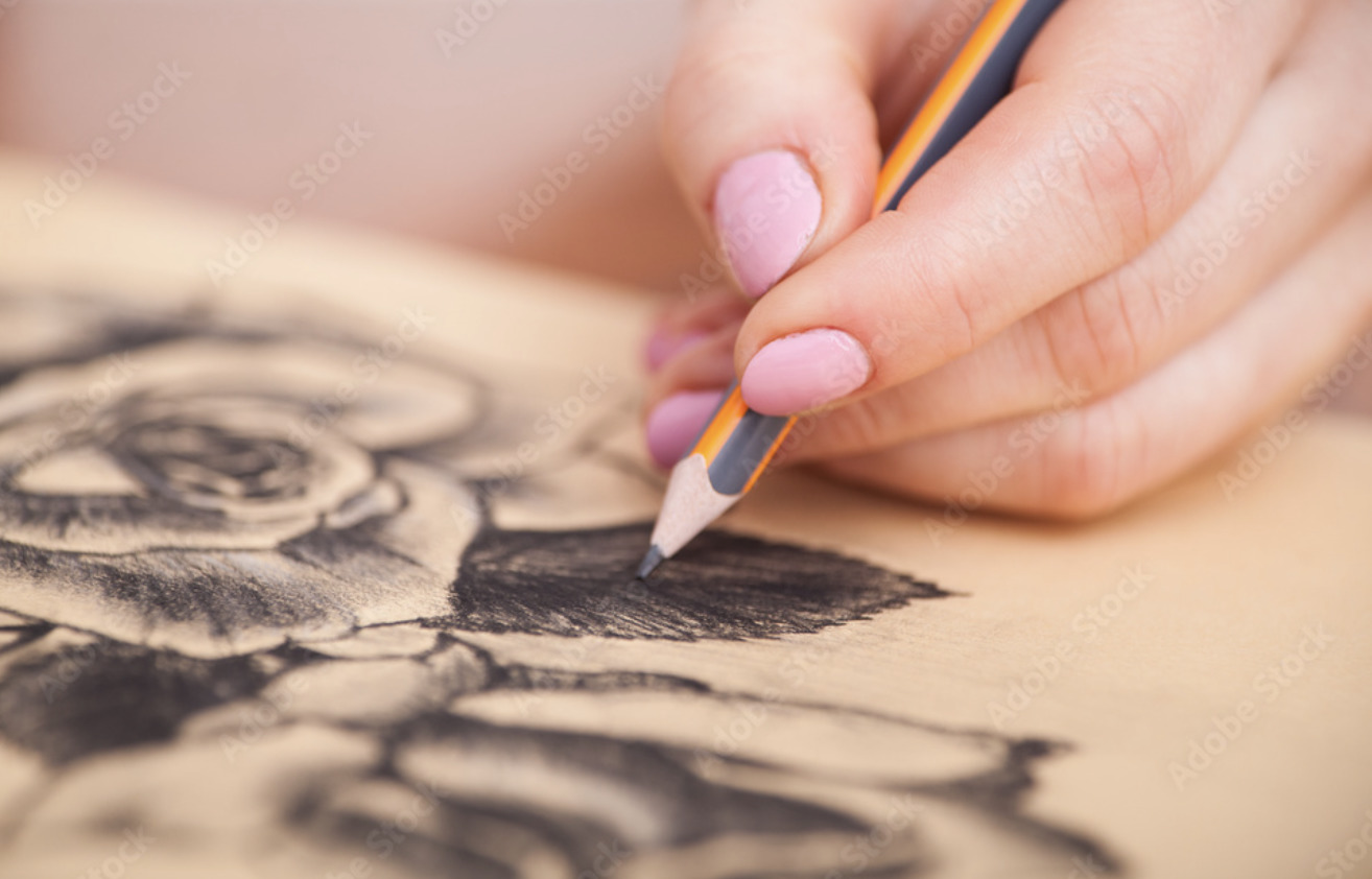 a woman is drawing a flower with a pencil