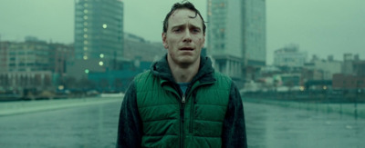 a man in a green jacket standing in the rain