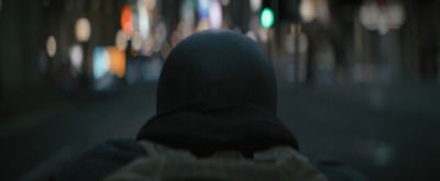 a person in a hooded jacket walking down a street