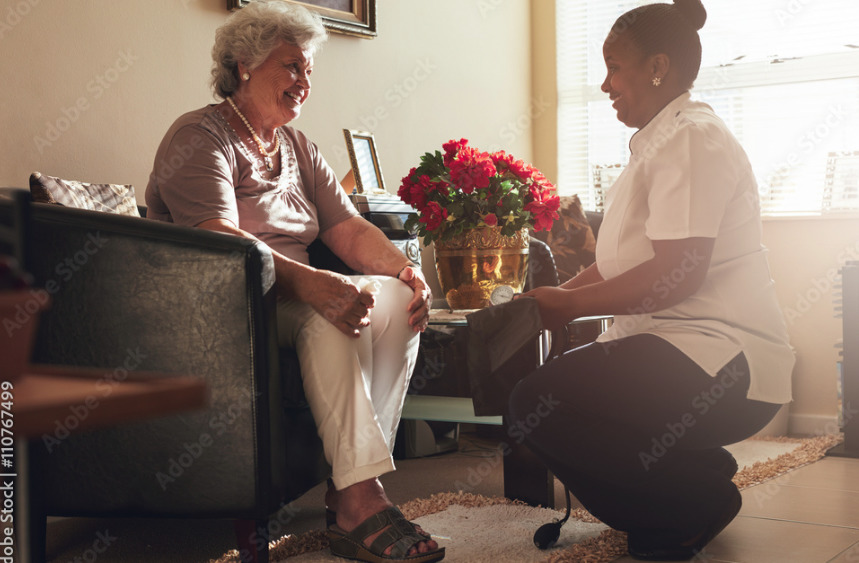 a woman sitting on a chair talking to another woman