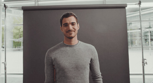 a man standing in front of a black backdrop