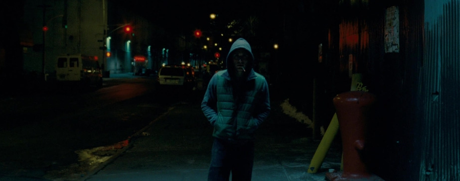 a man standing on a sidewalk in the dark