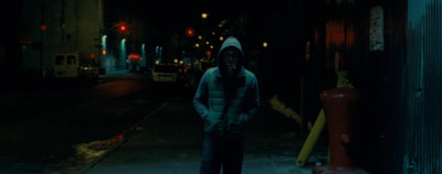 a man standing on a sidewalk in the dark