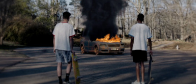 a couple of young men standing next to each other on a road