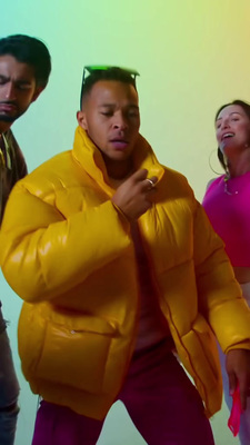 a man in a yellow puffer jacket standing next to a woman in a pink