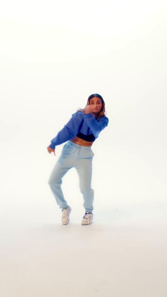 a woman in a blue sweater is dancing