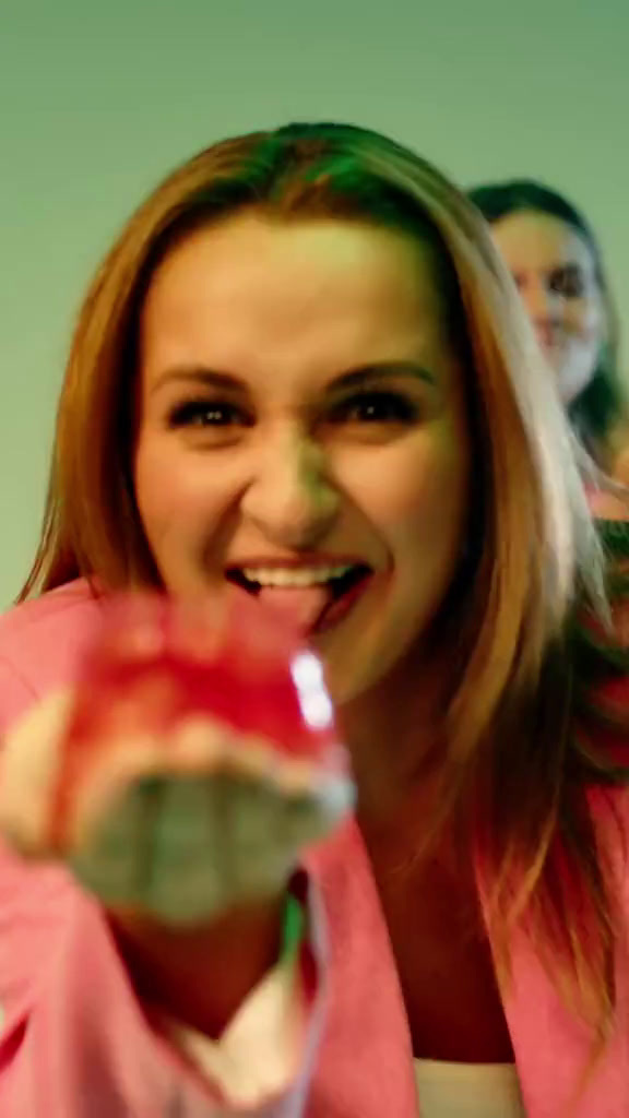 a woman is smiling and holding a glass