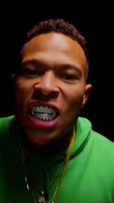 a man in a green hoodie with his mouth open