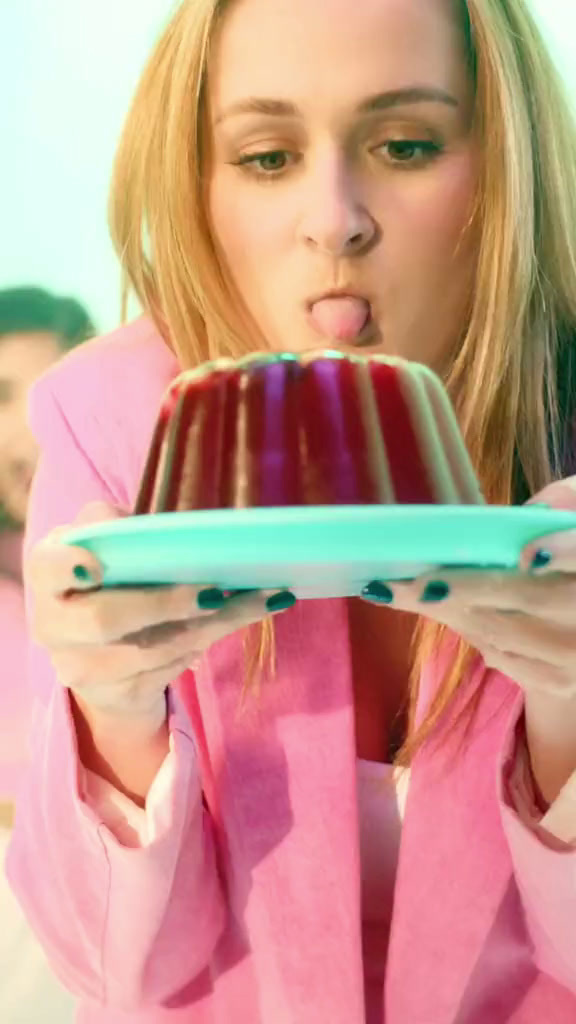 a woman in pink shirt holding a plate with a cake on it