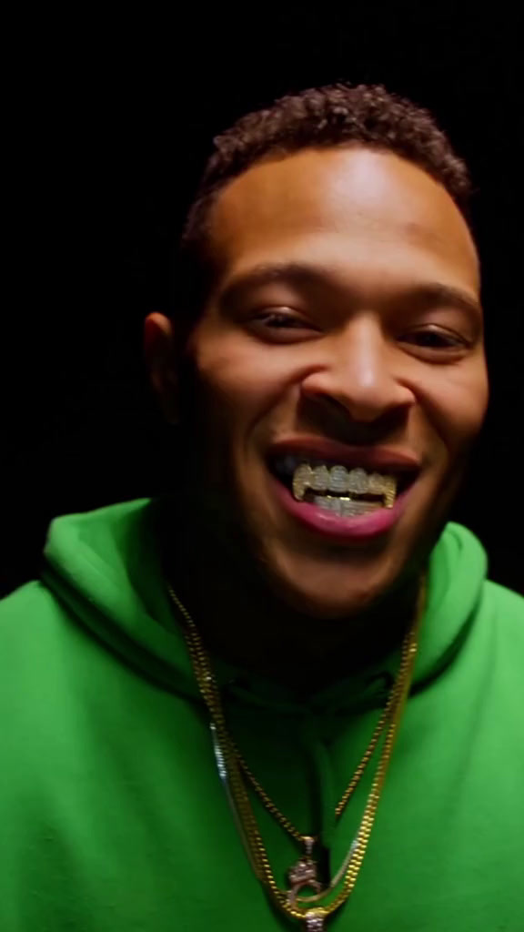 a man in a green hoodie with a smile on his face