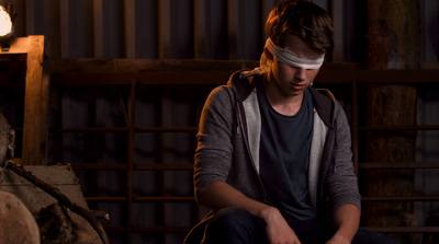 a man with a blindfold is sitting down