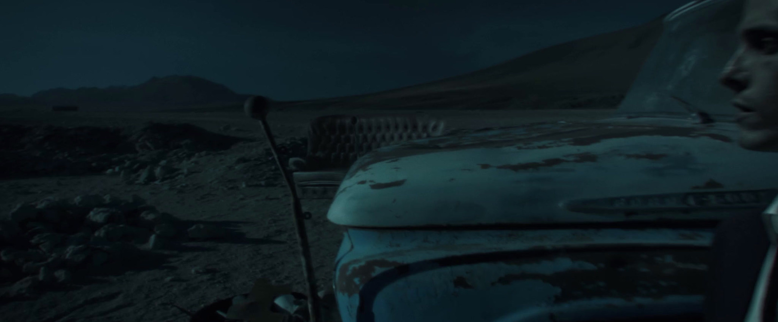 a man standing next to an old car in the dark