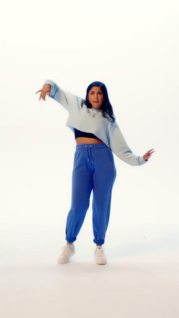 a woman in blue pants and a white sweater