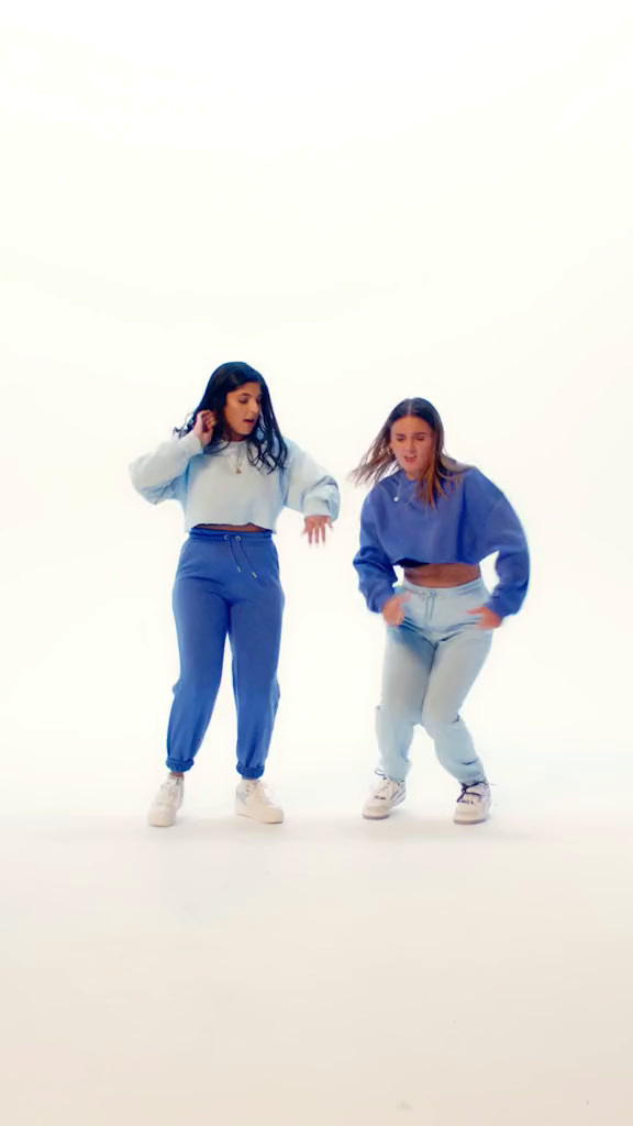 two women in matching outfits are posing for a picture