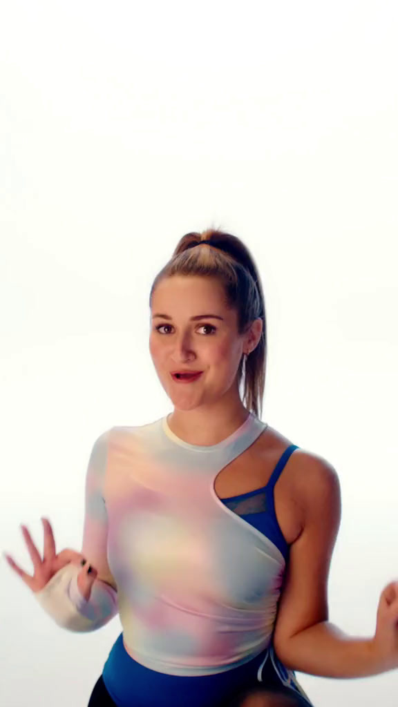 a woman in a blue and white top is holding a ball