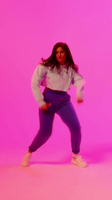 a woman standing in front of a pink background