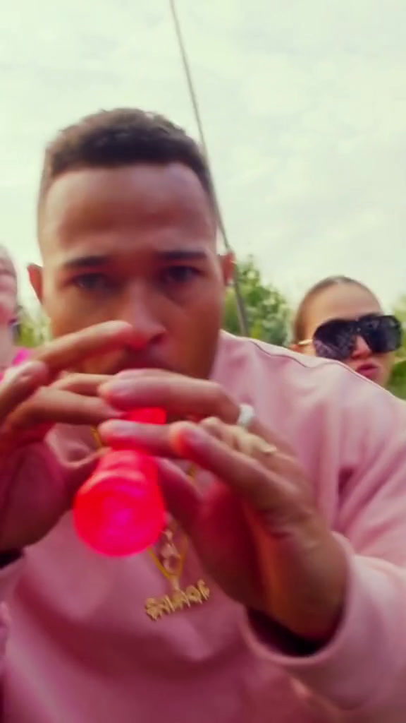 a man in a pink hoodie eating a donut