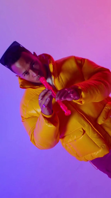 a man in a yellow jacket holding a pink toothbrush