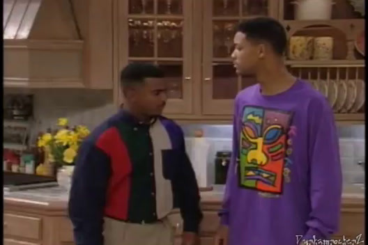 two men standing in a kitchen talking to each other