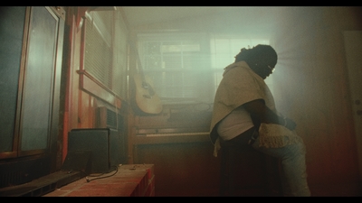a person standing in a room with a guitar