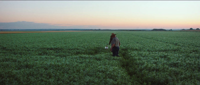 a man standing in a large green field