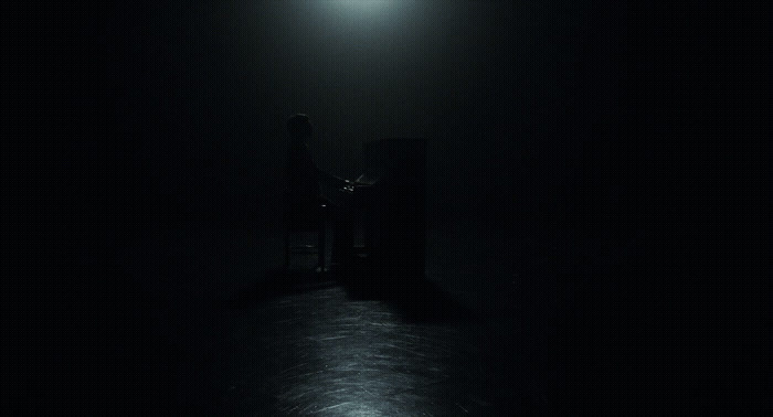 a person sitting in a chair in a dark room