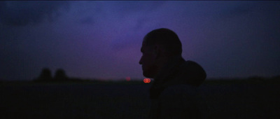 a man standing in a field at night