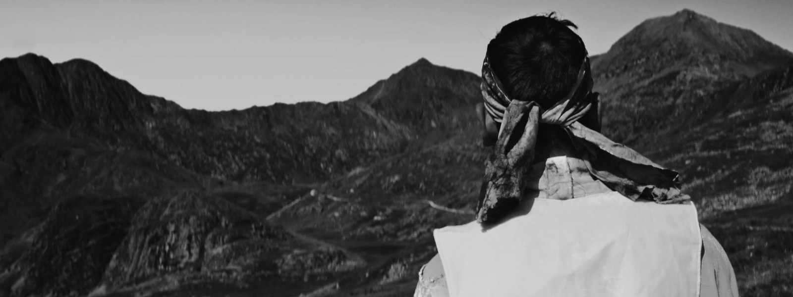 a black and white photo of a person with a bird on their head