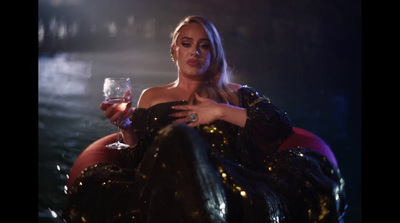 a woman in a black dress holding a glass of wine