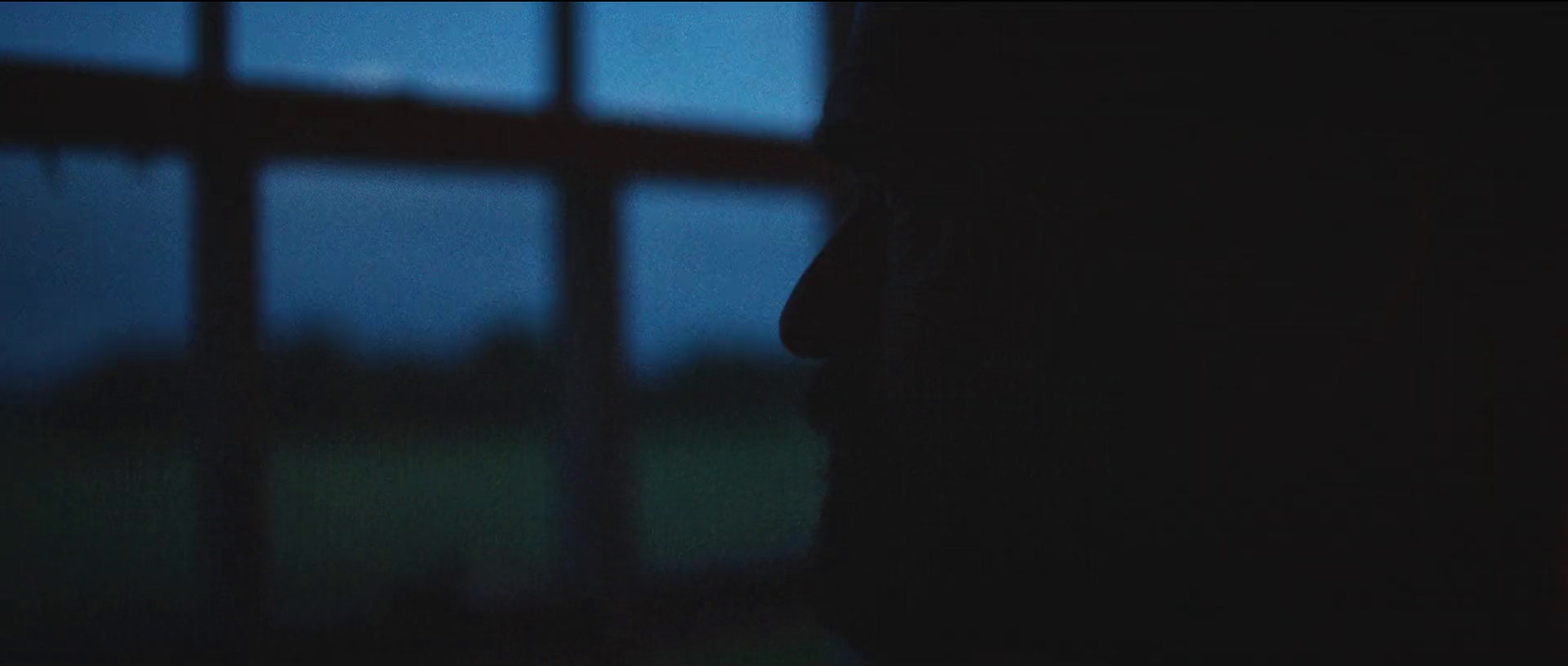 a person standing in front of a window at night