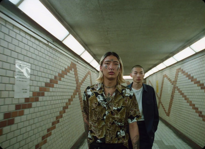 two young men walking down a long hallway