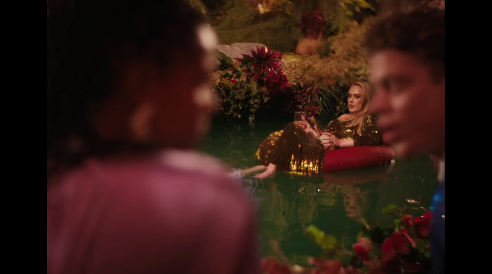 a woman sitting in a red boat in a pond