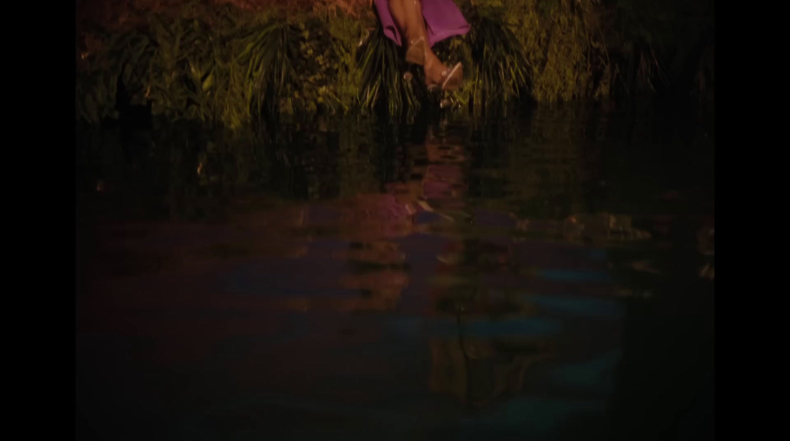 a woman in a purple dress is standing in the water